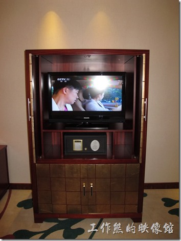 惠州-康帝國際酒店。液晶電視以及保險箱，電視有點小，可能是將就原來的電視櫃吧！電視櫃應該要改成開放式可以旋轉的樣式，這樣坐在書桌前也可以看電視，像現在這樣就只能躺在床上看電視。