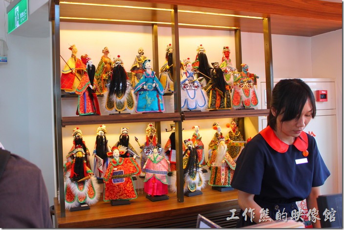 台南林百貨頂樓樓梯間販賣著各式紀念品，櫃檯後面是台灣傳統的布袋戲人偶。