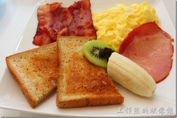 台南-看見咖啡(Vedere)早午餐。經典早午餐，NT$200。有三條培根、一份炒蛋、一片火腿、一片奇異果、半截香蕉，兩片烤過的對切薄吐司，是一份非常豐盛的早餐。炒蛋軟嫩軟嫩的很好吃