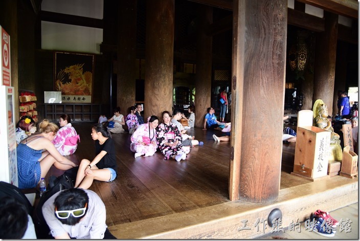 清水寺本堂內必須拖鞋才能入內，可以看到木柱旁坐滿了休息的遊客。